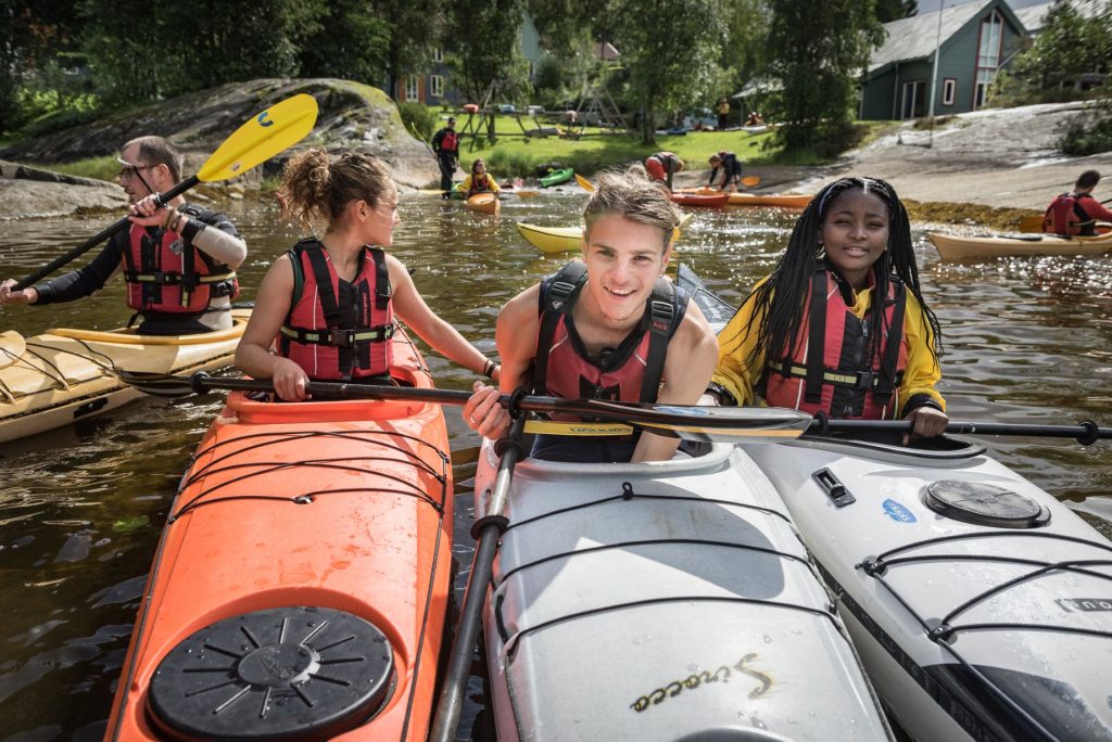 Students sitting on kayaks