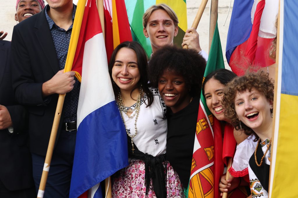 Students holding flags and wearing their national dress