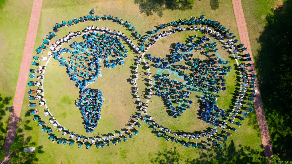 Aerial photo of students lining up to form the UWC globe logo.
