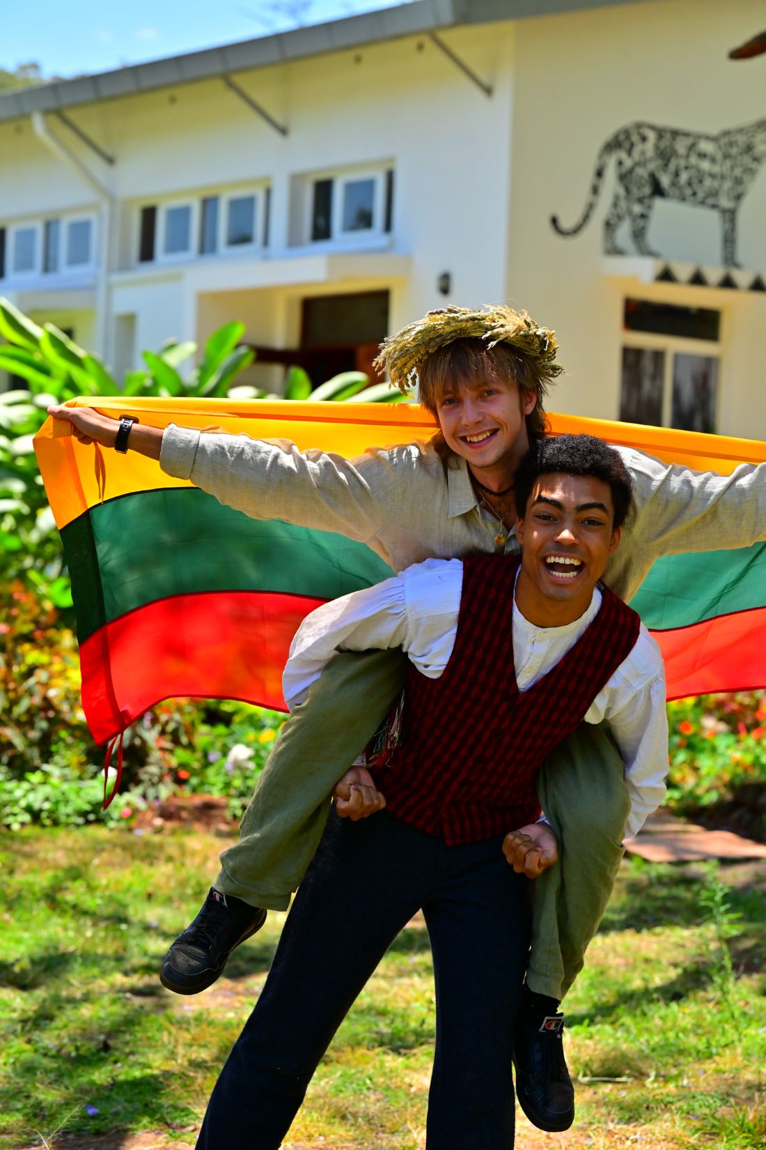 Student giving another student on his back while carrying a flag