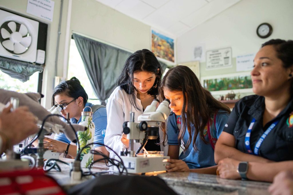 Student looking down a microscope in science class