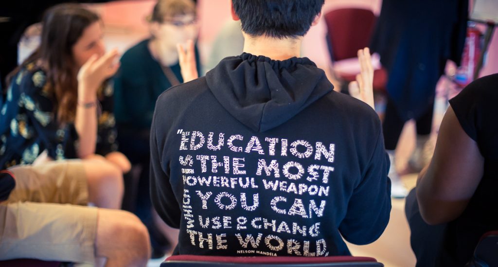 The back of a male wearing a hoodie with the text ' education is the most powerful weapon you can use to change the world.'