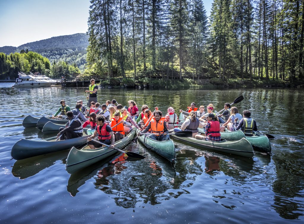 A group of students in kayaks in a fan shape